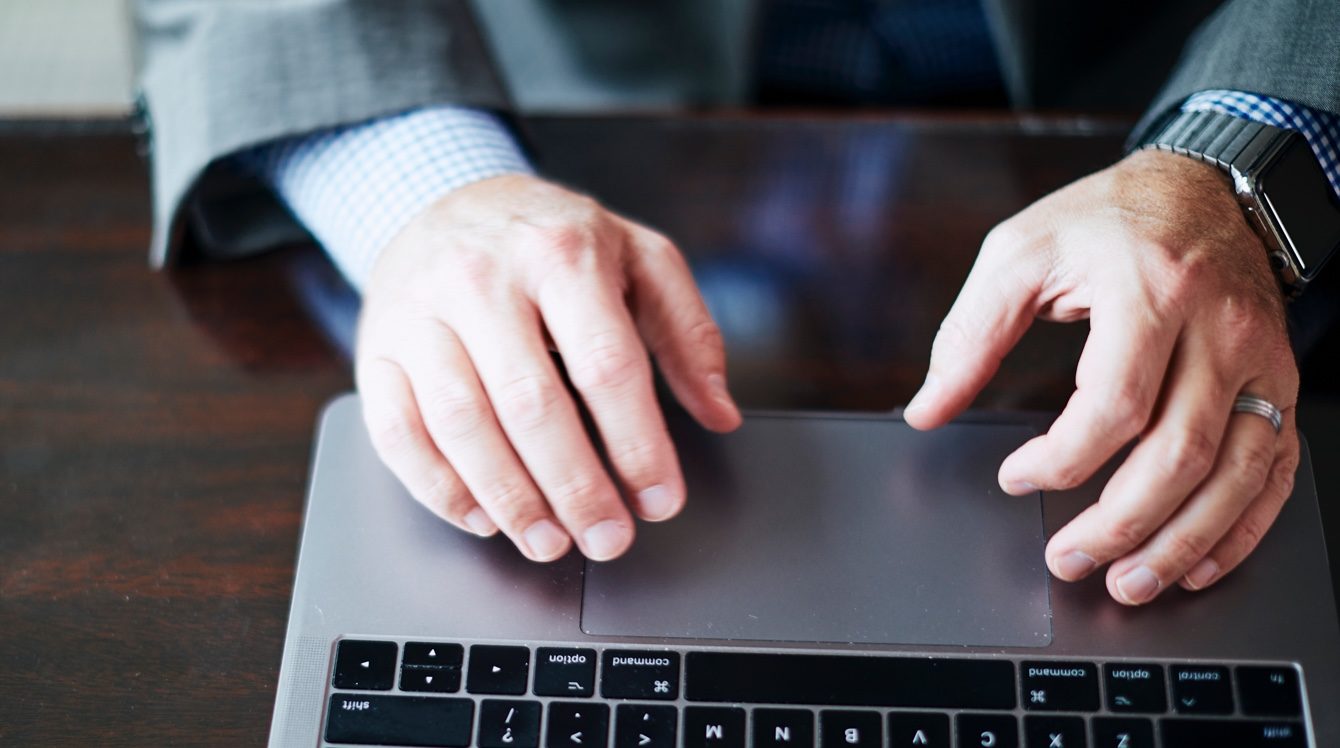 Hands resting on a laptop computer